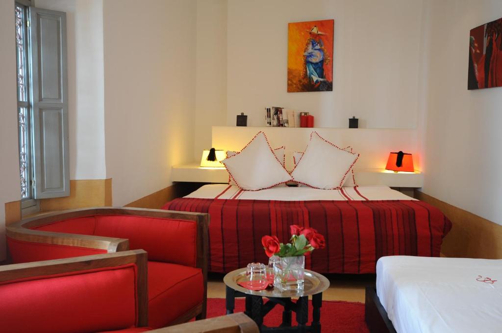 ein Hotelzimmer mit einem Bett, einem Stuhl und einem Tisch in der Unterkunft Riad Dar Asam in Marrakesch