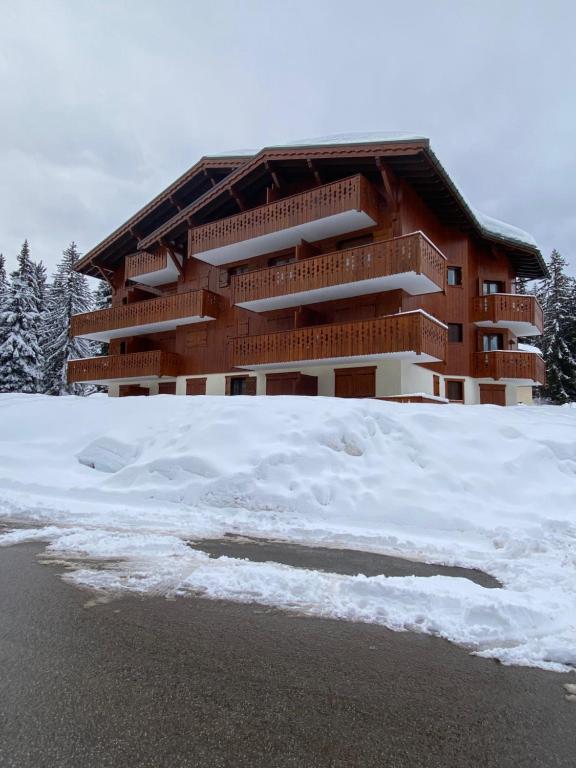 un bâtiment avec de la neige devant lui dans l'établissement Appartement les Saisies, à Villard-sur-Doron