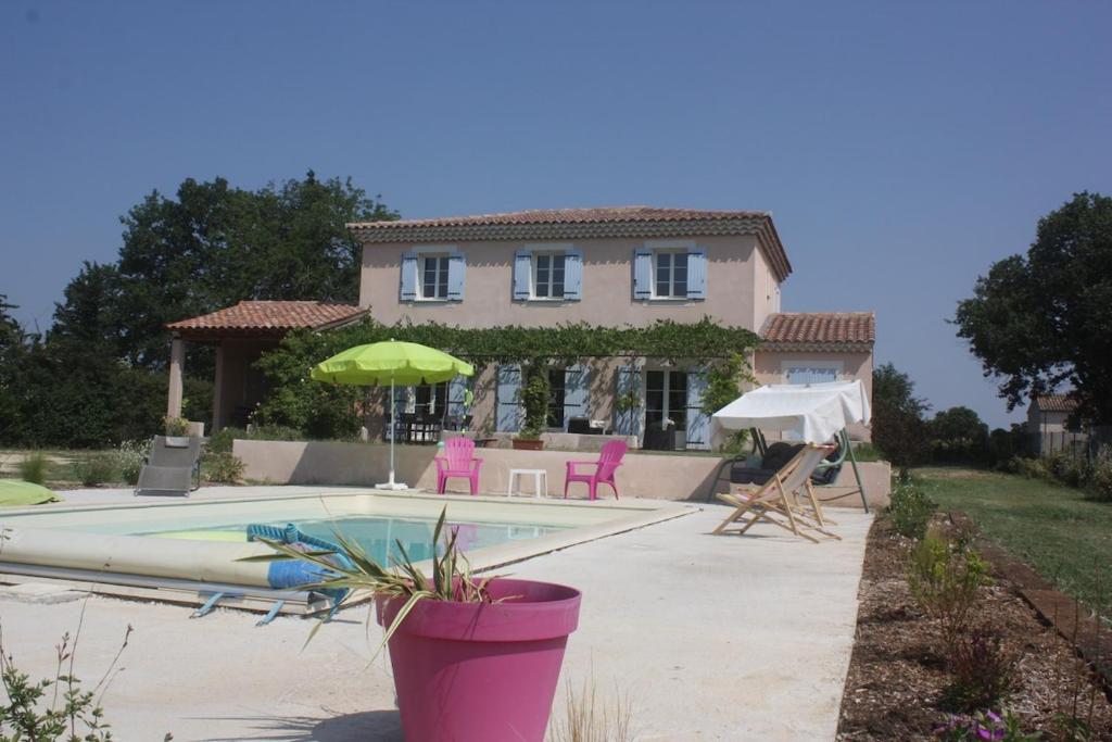 une maison avec une piscine devant une maison dans l'établissement Bastide provençale avec piscine privée, à Sainte-Cécile-les-Vignes