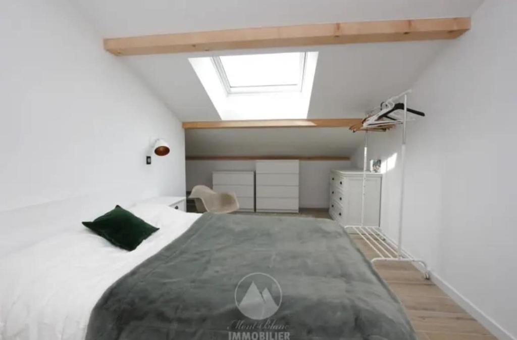 - une chambre avec un grand lit et une lucarne dans l'établissement Appartement 2 chambres - Les Houches, aux Houches