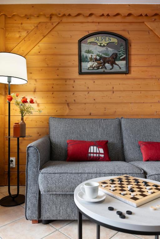 a living room with a couch and a chessboard on a table at Résidence Pierre & Vacances Premium Les Fermes De Méribel in Méribel