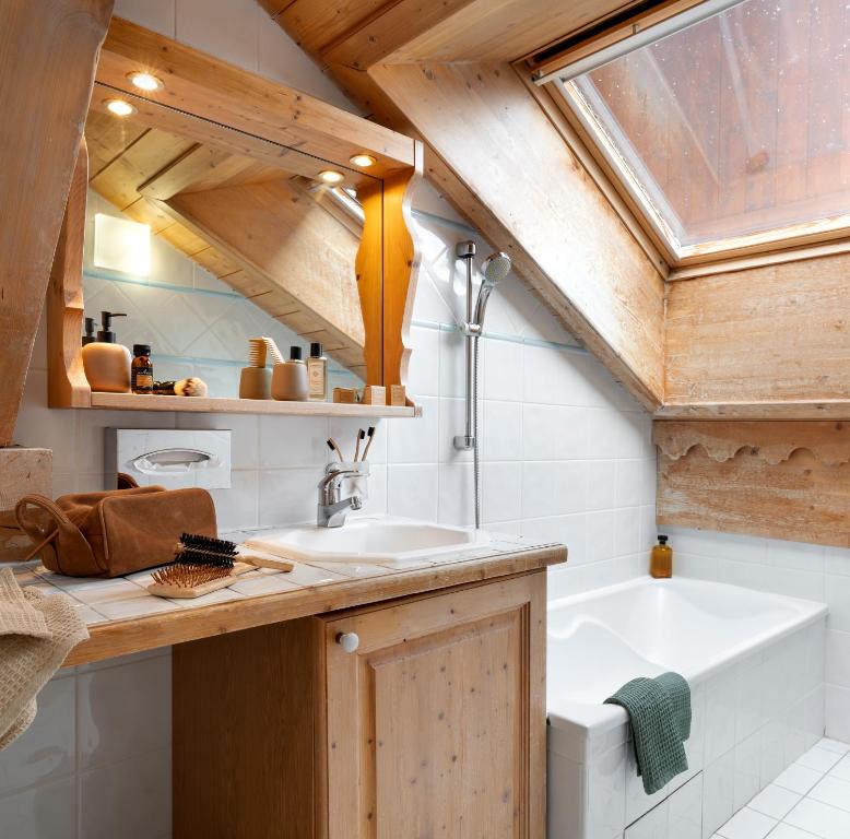 a bathroom with a sink and a bath tub at Résidence Pierre & Vacances Premium Les Fermes De Méribel in Méribel