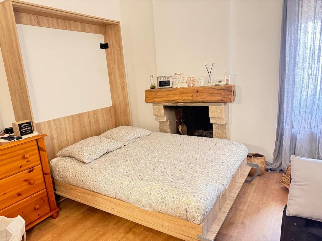 a bedroom with a bed and a fireplace at Location atypique village olmeto in Olmeto