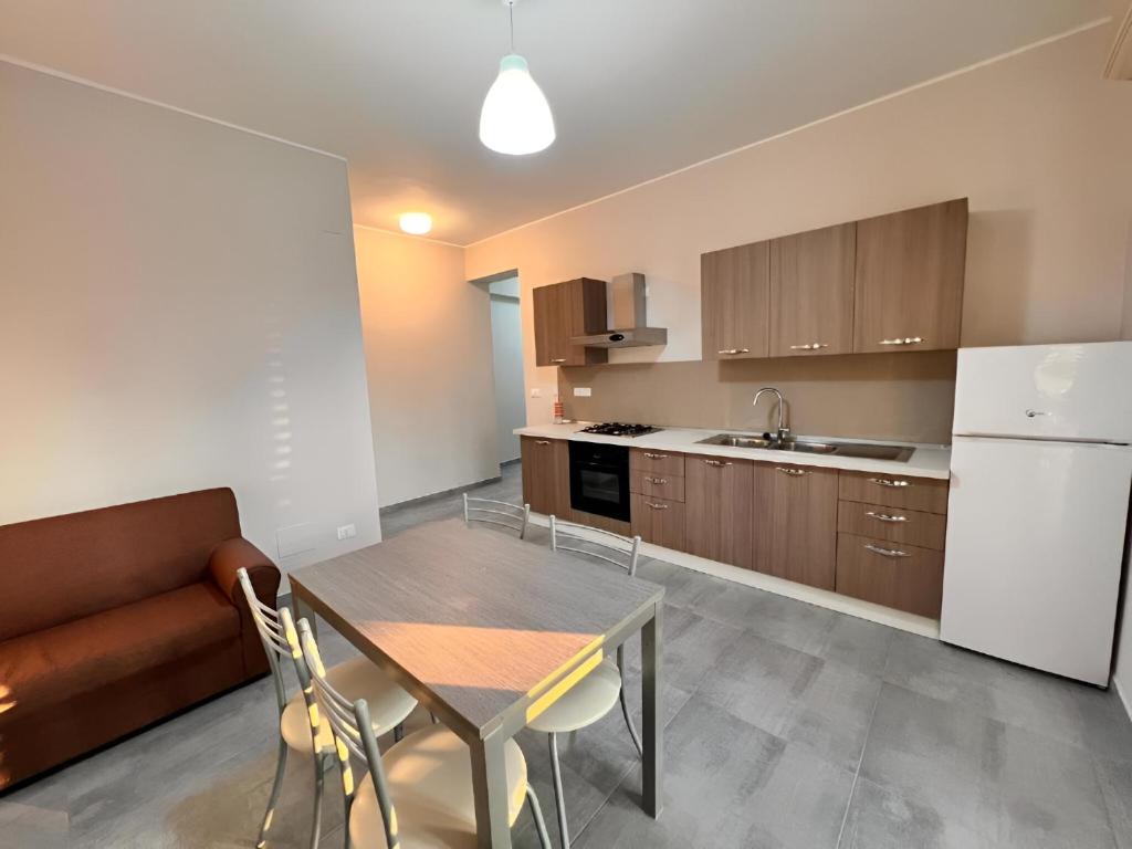 eine Küche und ein Esszimmer mit einem Tisch und einer Couch in der Unterkunft La Piazzetta in Olivarella
