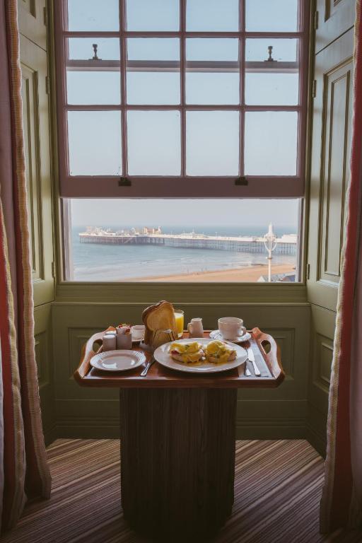 a table with a plate of food and a window at Drakes Hotel in Brighton & Hove