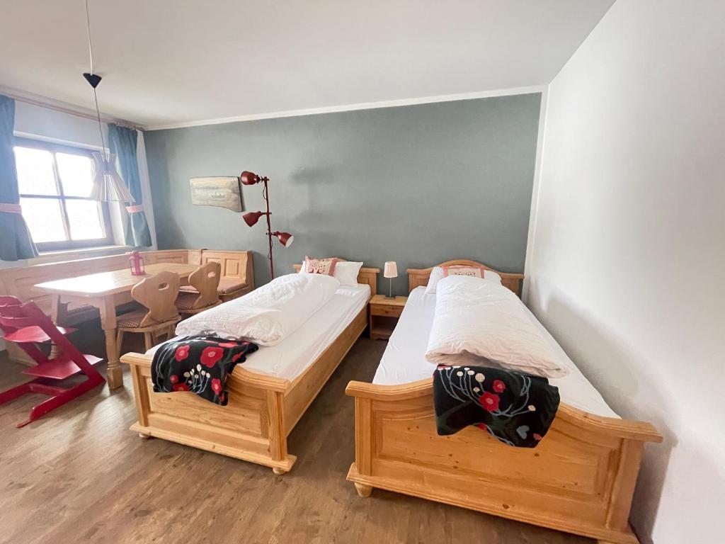 two twin beds in a room with a table at Ferienwohnung Berglodge Chiemsee in Aschau im Chiemgau