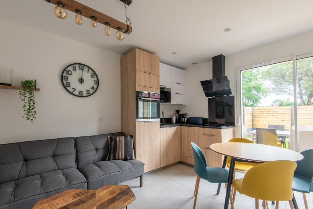 比斯卡罗斯Le bleu cargo的客厅里有一张沙发，墙上挂着一只钟