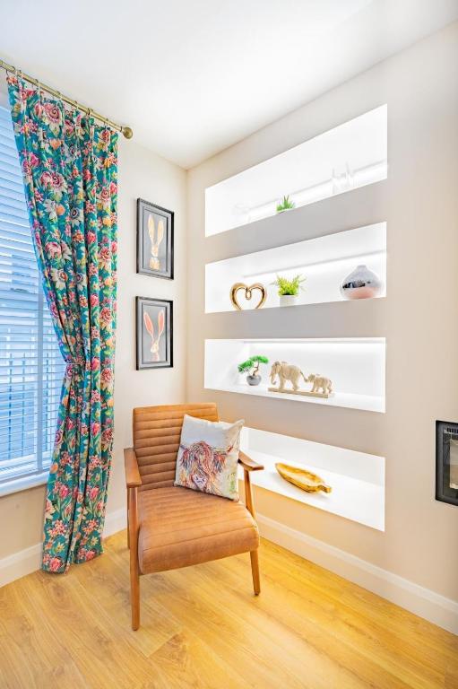 a living room with a chair and shelves at The Townhouse Ballycastle in Ballycastle