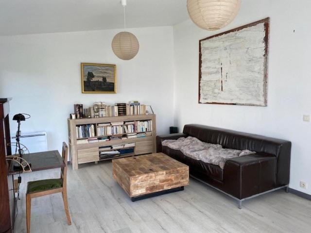 un salon avec un canapé et une étagère dans l'établissement Maison TOTORO, à Heugueville-sur-Sienne