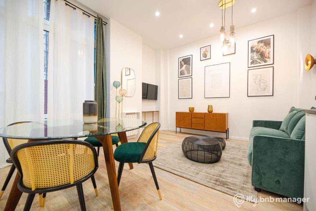un salon avec une table en verre et des chaises dans l'établissement CIA - Flat on rue La Fayette, à Paris