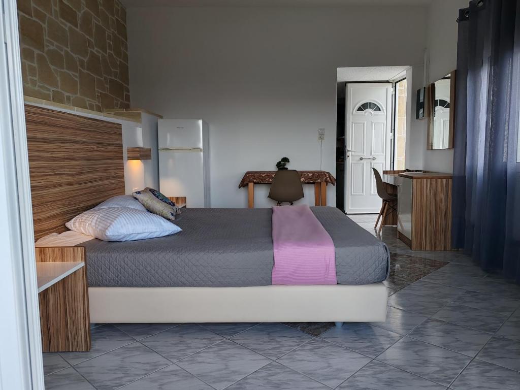ein Schlafzimmer mit einem großen Bett und einem Schreibtisch in der Unterkunft Jacob's cottage Ideal Base for Balos & Elafonisi in Kissamos