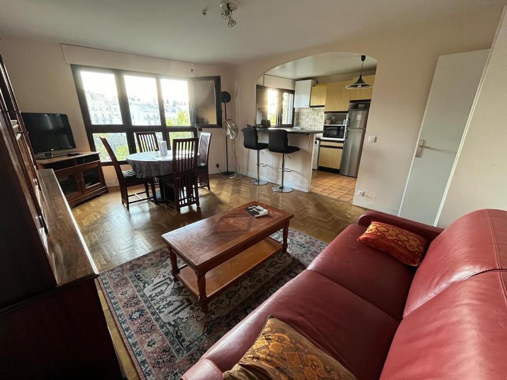 un salon avec un canapé et une table dans l'établissement Spacious and bright apartment 2min from Paris, à Saint-Mandé
