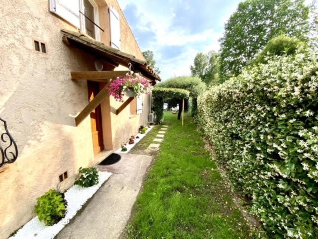 Une ruelle à côté d'un bâtiment fleuri dans l'établissement Villa Lagon, à Villeneuve-Loubet