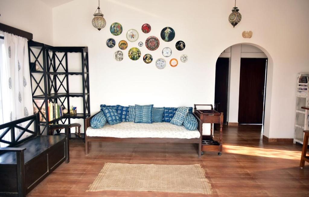a living room with a couch and plates on the wall at Casa Terrazzo,2bhk apartment in Sucorro-Porvorim in Pilerne