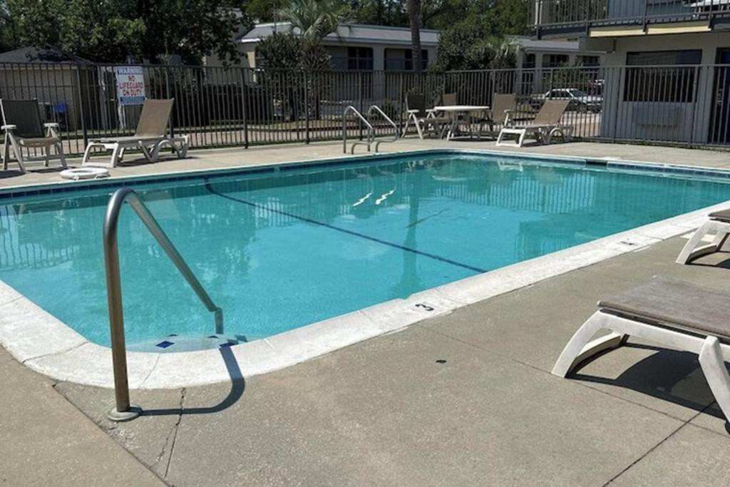 ガルフポートにあるMotel 6 Gulfport, MS Airportの青い大型スイミングプール(椅子、テーブル付)