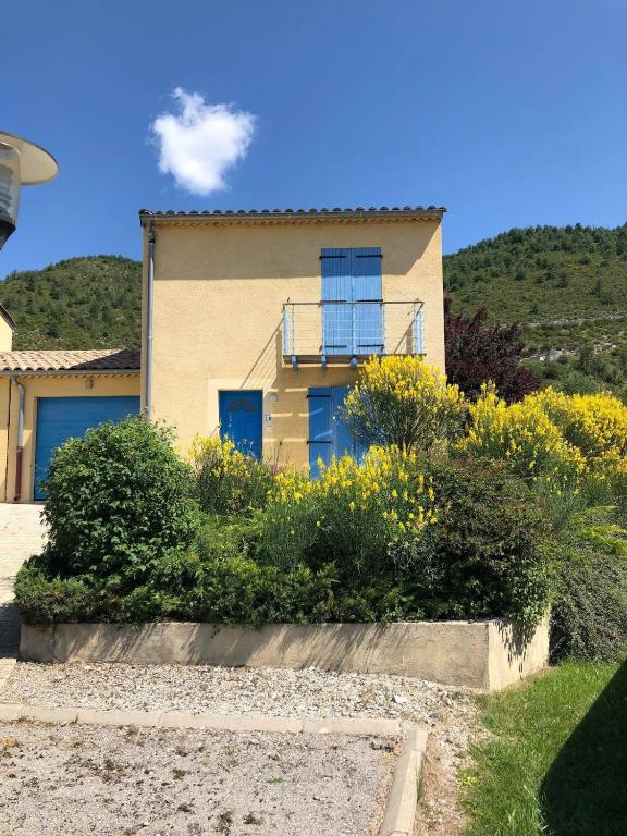 une maison avec des fleurs jaunes devant elle dans l'établissement Fitis ! 6 person villa with 1 pool on a residence, à Castellane