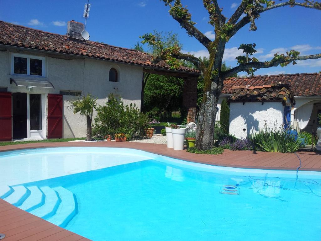 a swimming pool in front of a house at Le Clos de Saint Amour in Montauban