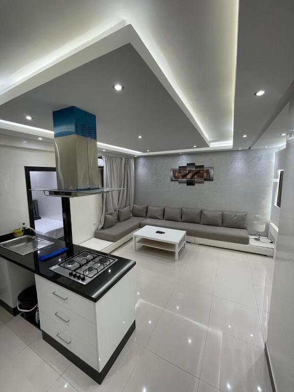 cocina con fogones y sofá en una habitación en Apartement abwab gueliz, en Marrakech