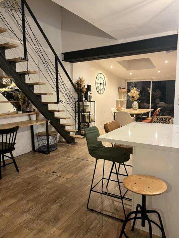 une pièce avec un escalier, une table et des chaises dans l'établissement Maison 6 personnes - Idéal 24h du Mans, au Mans