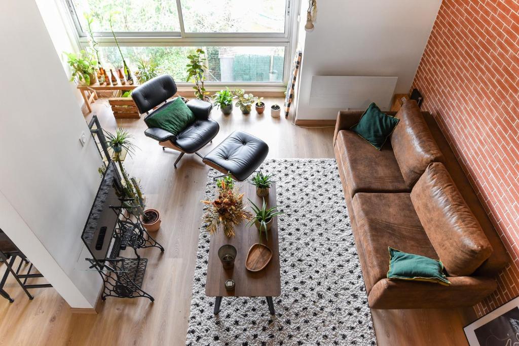 - un salon avec un canapé et des fauteuils en cuir brun dans l'établissement Le Loft Botanique Et Son Parking Gratuit, à Toulouse