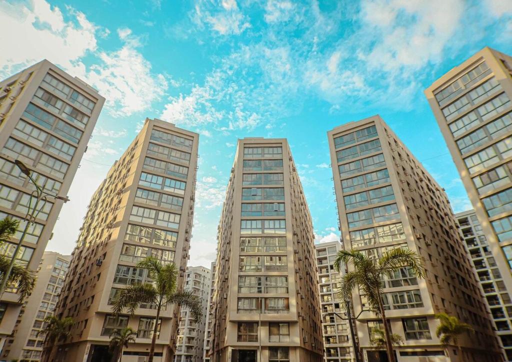 four tall buildings in a city with palm trees at Luxury Furnished Condo in Egypt in Cairo