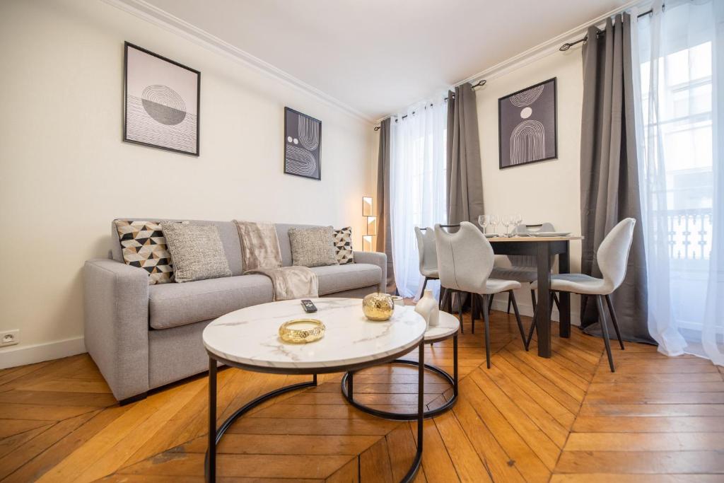 un salon avec un canapé et une table dans l'établissement CIA - rue du Colisée, near Champs Élysées, à Paris