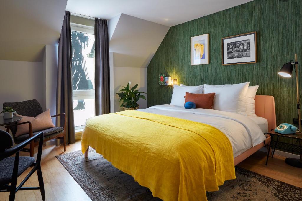 ein Schlafzimmer mit einem großen Bett und einer gelben Decke in der Unterkunft Max Brown Hotel 7th District, part of Sircle Collection in Wien