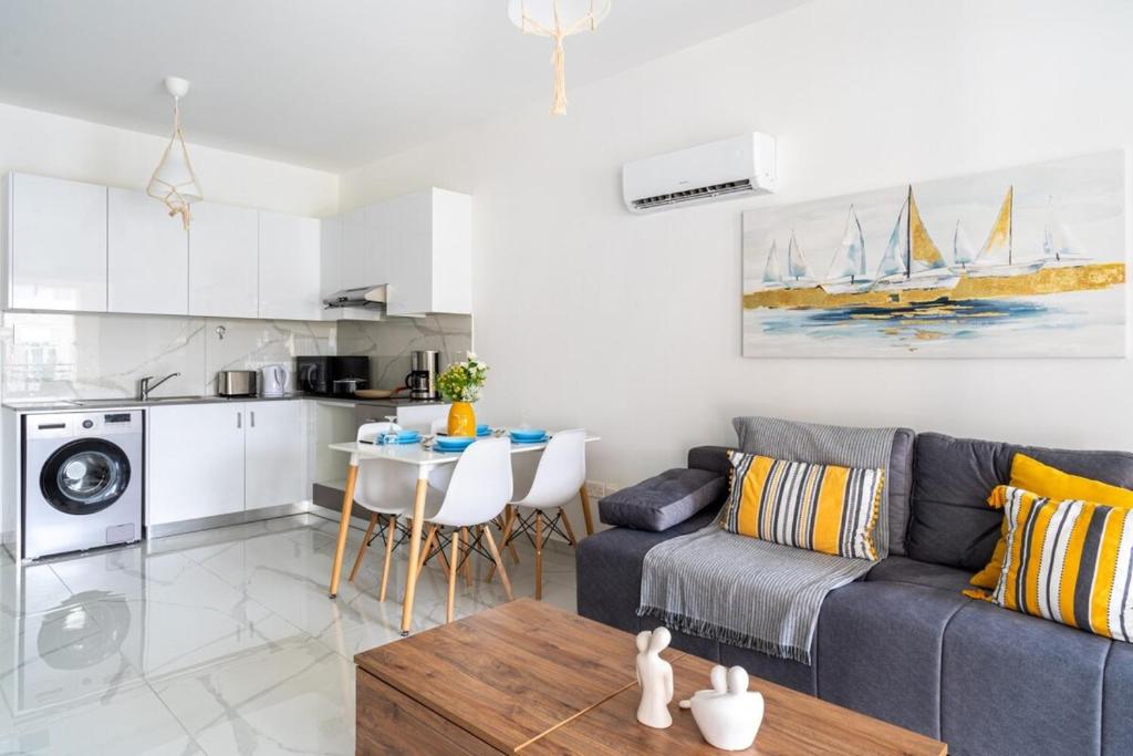 a living room with a couch and a table and a kitchen at Infinity - One-Bedroom Apt W Terrace in Larnaca in Larnaca