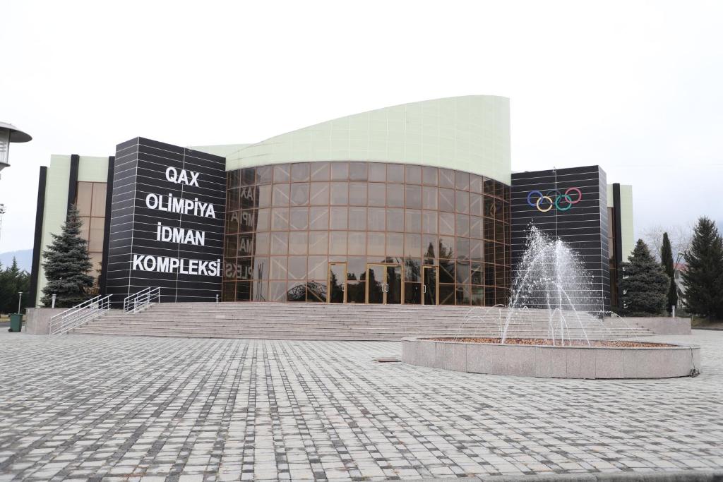 a large building with a fountain in front of it at Arena Hotel Qakh in Qax