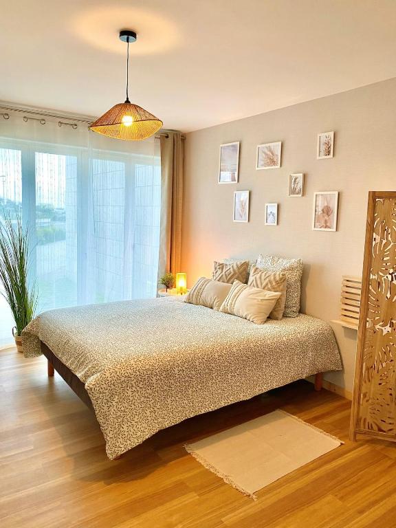 une chambre avec un lit et une grande fenêtre dans l'établissement L entre deux, à Sangatte