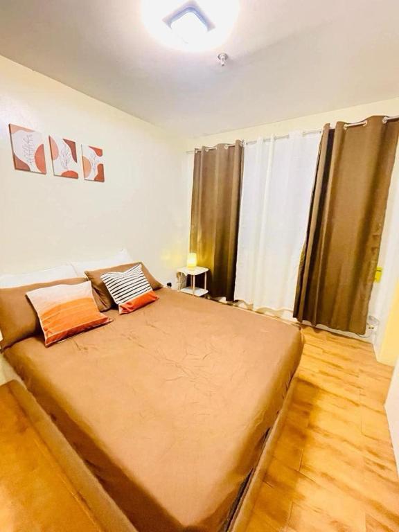 une chambre avec un grand lit dans une pièce dans l'établissement Seawind Damosa Condominium, à Davao