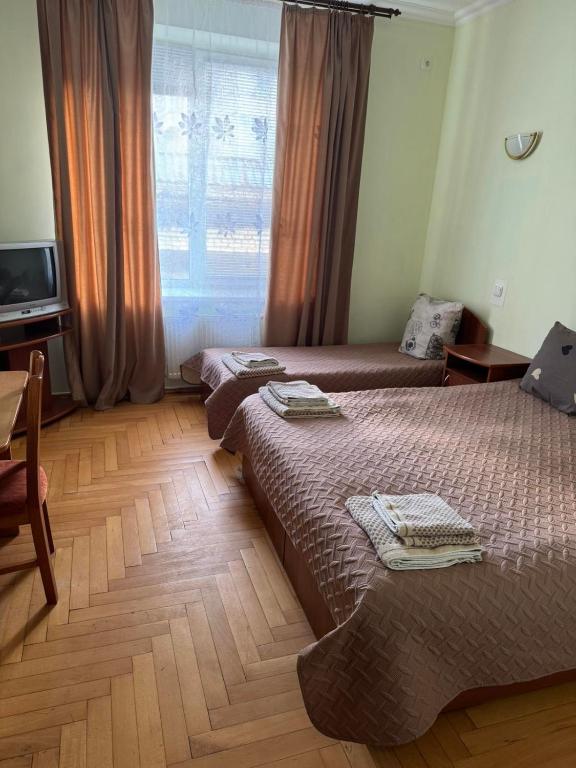a hotel room with two beds and a window at Готель "Український Дворик" in Lviv