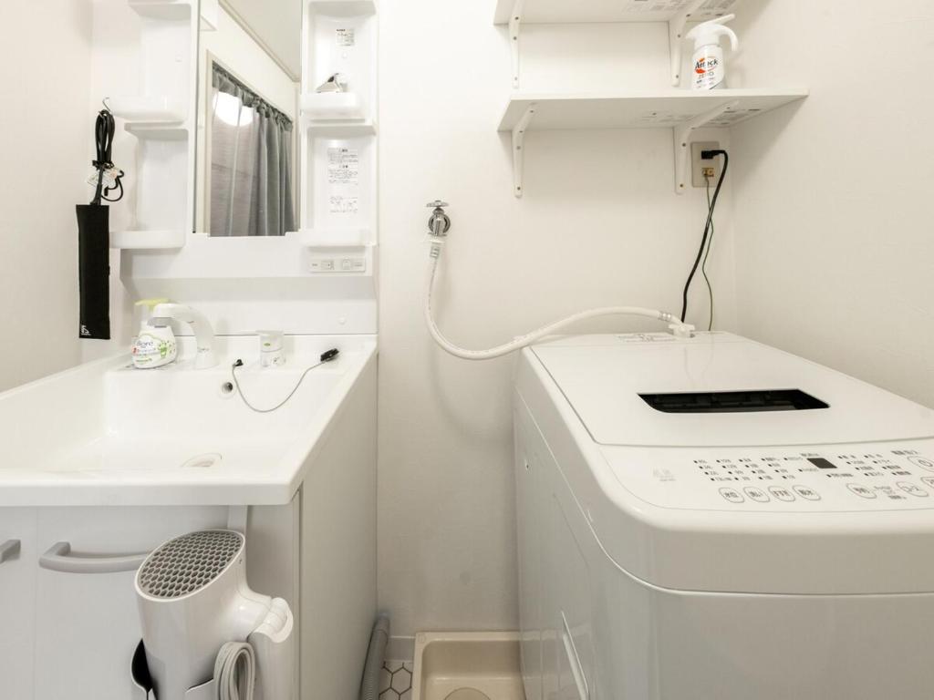 大阪MYB Namba 3BR suite close to Namba Self Check-In的白色的浴室设有水槽和洗衣机。