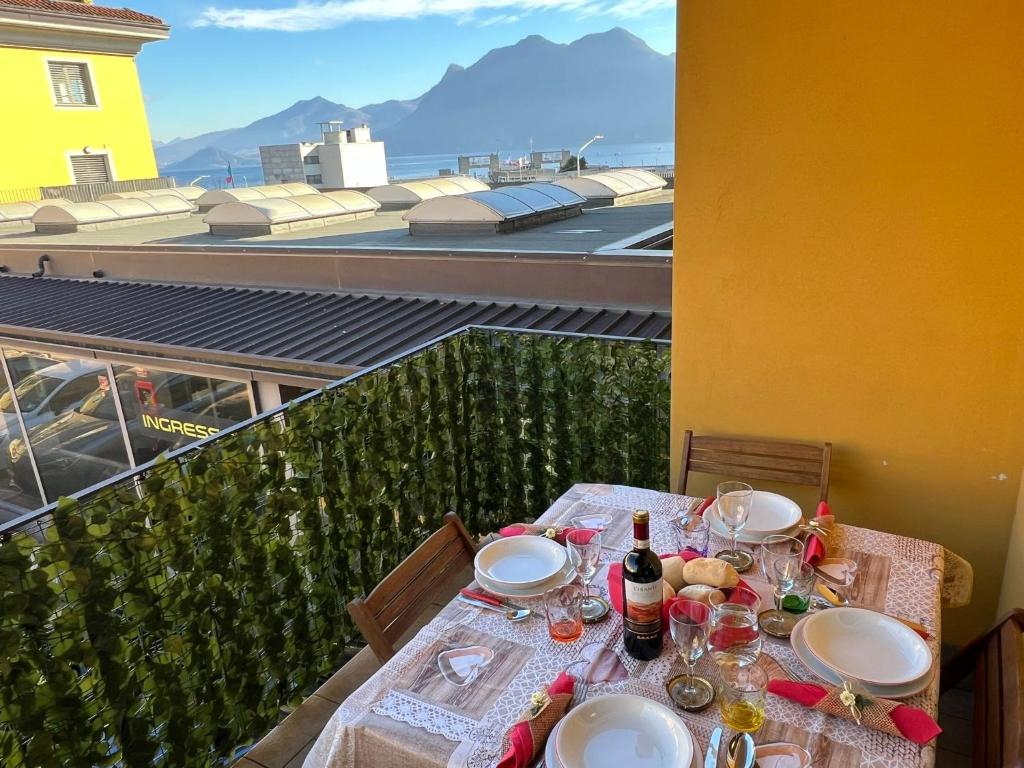 einen Tisch mit Tellern und Weinflaschen auf dem Balkon in der Unterkunft Giotto in Verbania