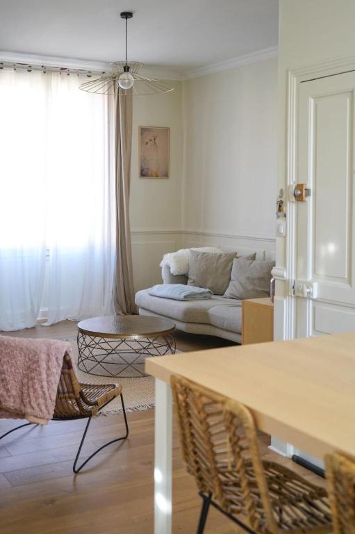 un salon avec un canapé, une table et des chaises dans l'établissement La Marie-Louise, à Brive-la-Gaillarde