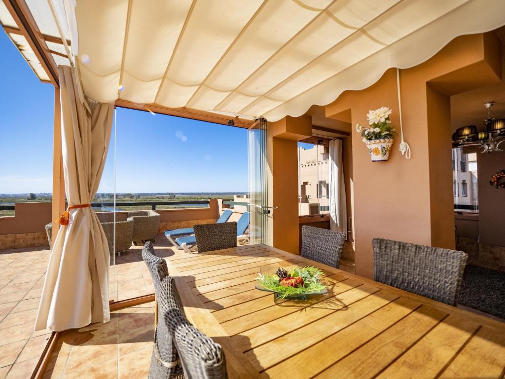ein Esszimmer mit einem Tisch und Stühlen mit Aussicht in der Unterkunft Playa Verde PLUS by Ĥ - Playa Punta del Moral PPHV58P39 in Punta del moral