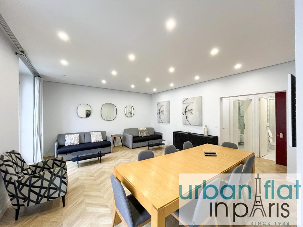 un salon avec une table et des chaises dans l'établissement 127 - Urban Beautiful 4BR in Montorgueil, à Paris