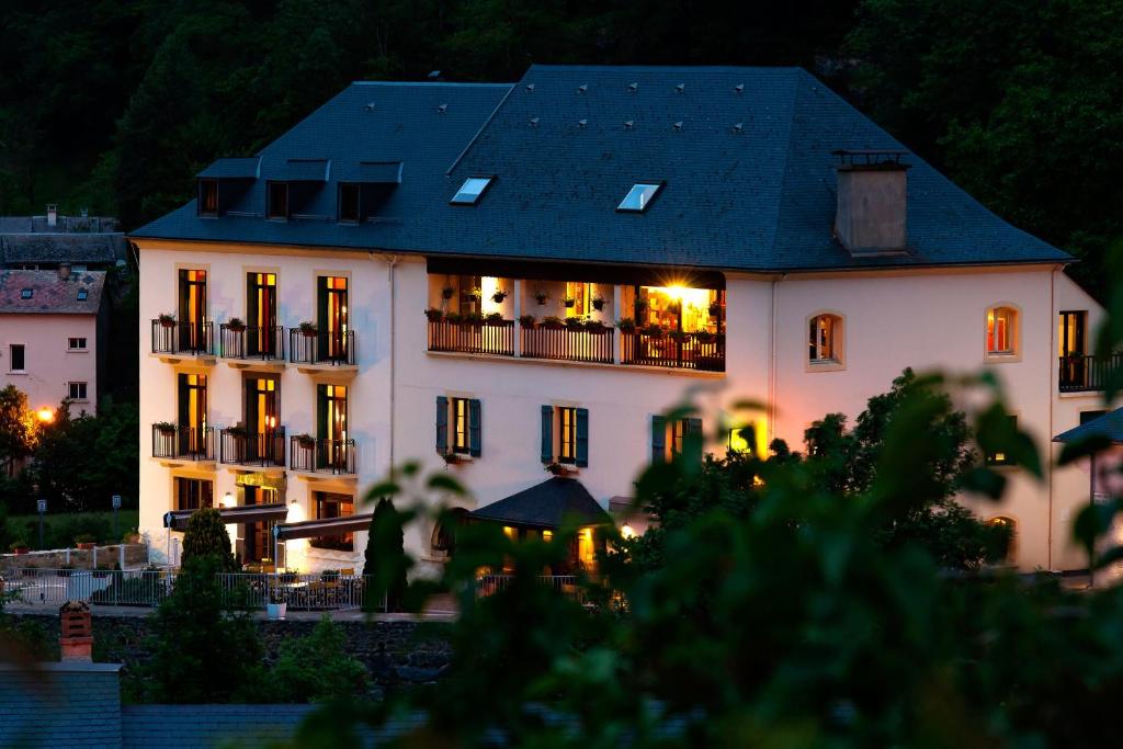 um grande edifício branco com um telhado preto em Logis Hôtel La Brèche de Roland em Gèdre