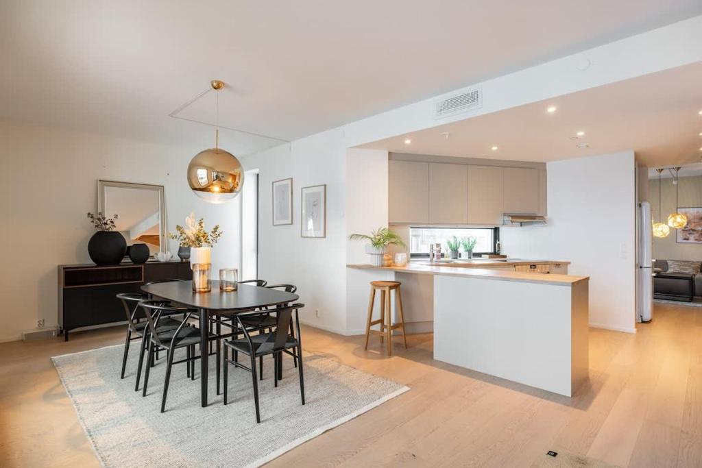 a kitchen and dining room with a table and chairs at DINBNB Apartments 800m to Oslo C Station l 133sqm l High-End in Oslo