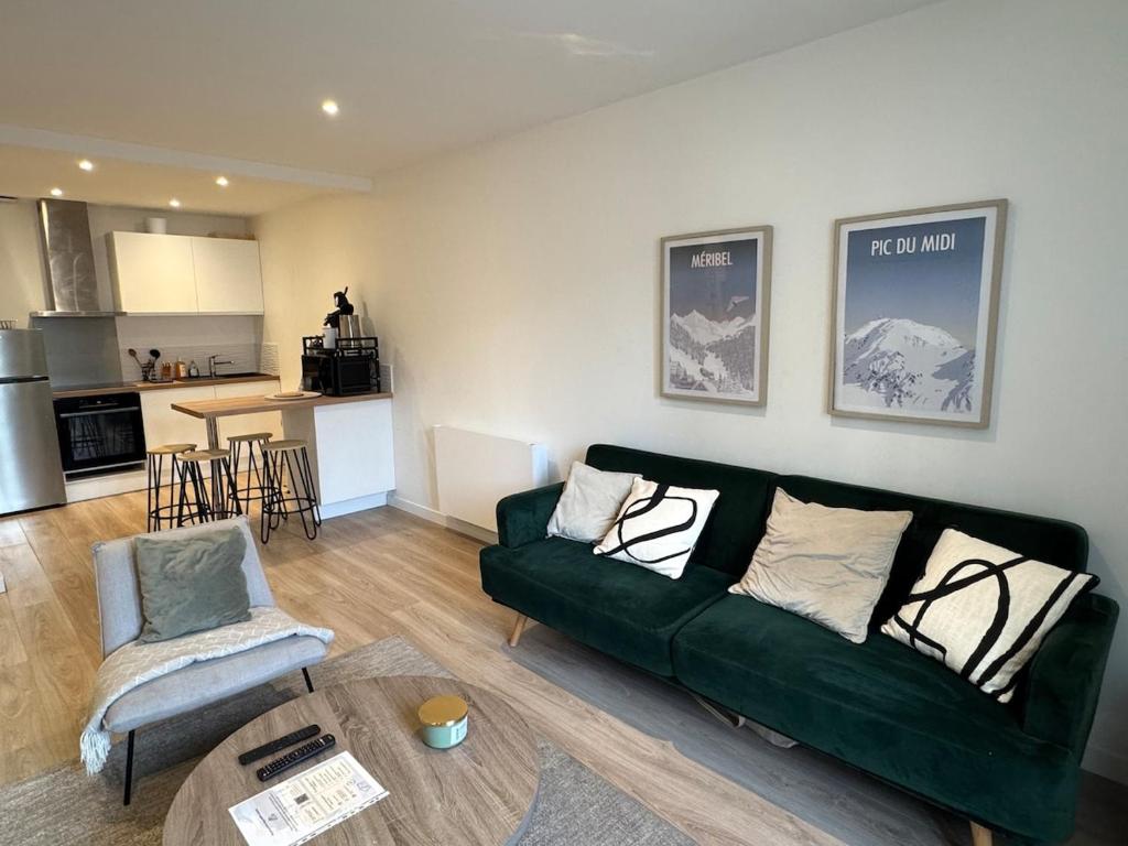 un salon avec un canapé vert et une table dans l'établissement T3 hyper centre, à Valence