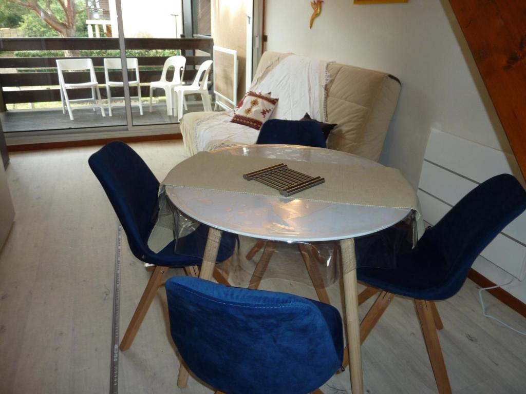 a table and chairs in a room with a couch at LE COURANT D'HUCHET in Moliets-et-Maa