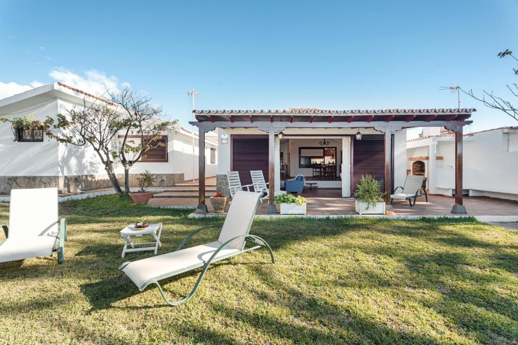 een achtertuin met stoelen en een prieel bij Villa del Mar Palm Mar in Palm-mar