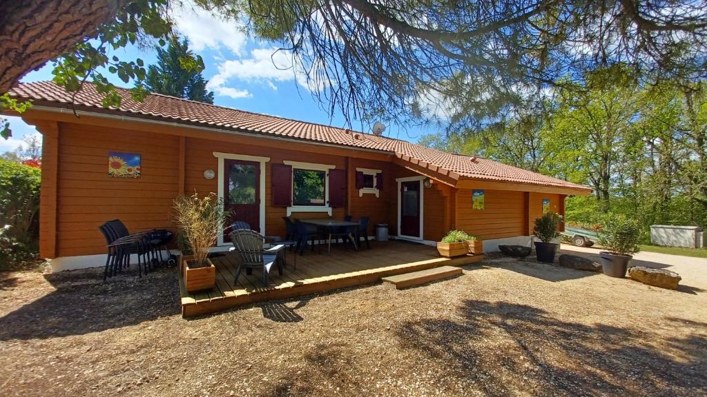 une petite maison en bois avec une table et des chaises dans l'établissement Chalet Lot, à Mauroux