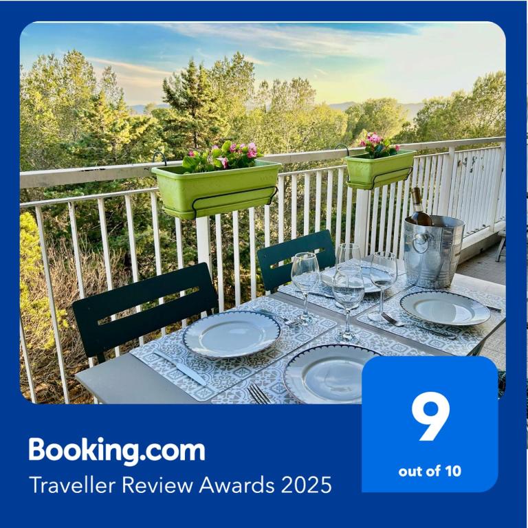 une table avec des assiettes et des verres sur un balcon dans l'établissement Appartement 72m² à Saint-Raphaël (83), à Saint-Raphaël