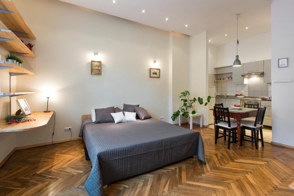 a bedroom with a bed and a table and a kitchen at Urban Studio Apartment in Krakow