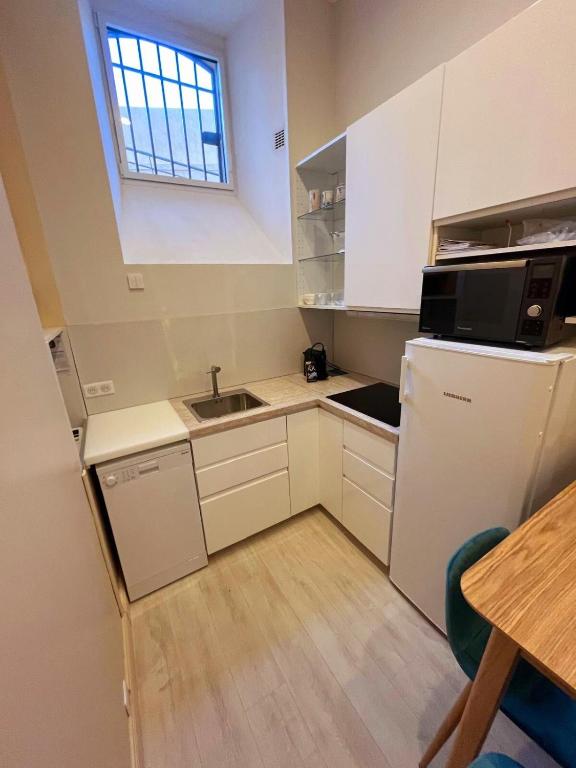 une petite cuisine avec un évier et un réfrigérateur dans l'établissement Studio Le Parc Continental Cannes, à Cannes