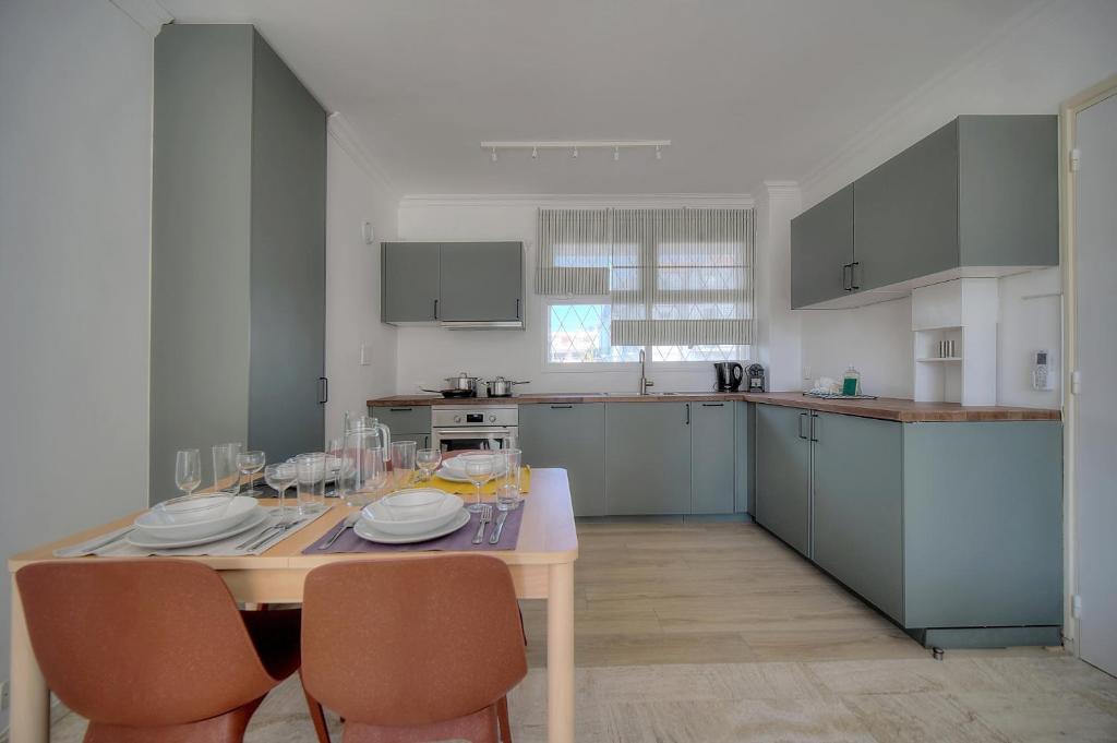- une cuisine avec une table, des chaises et une table dans l'établissement Immogroom - cosy apartment - Terrace - AC - Wifi, à Cannes