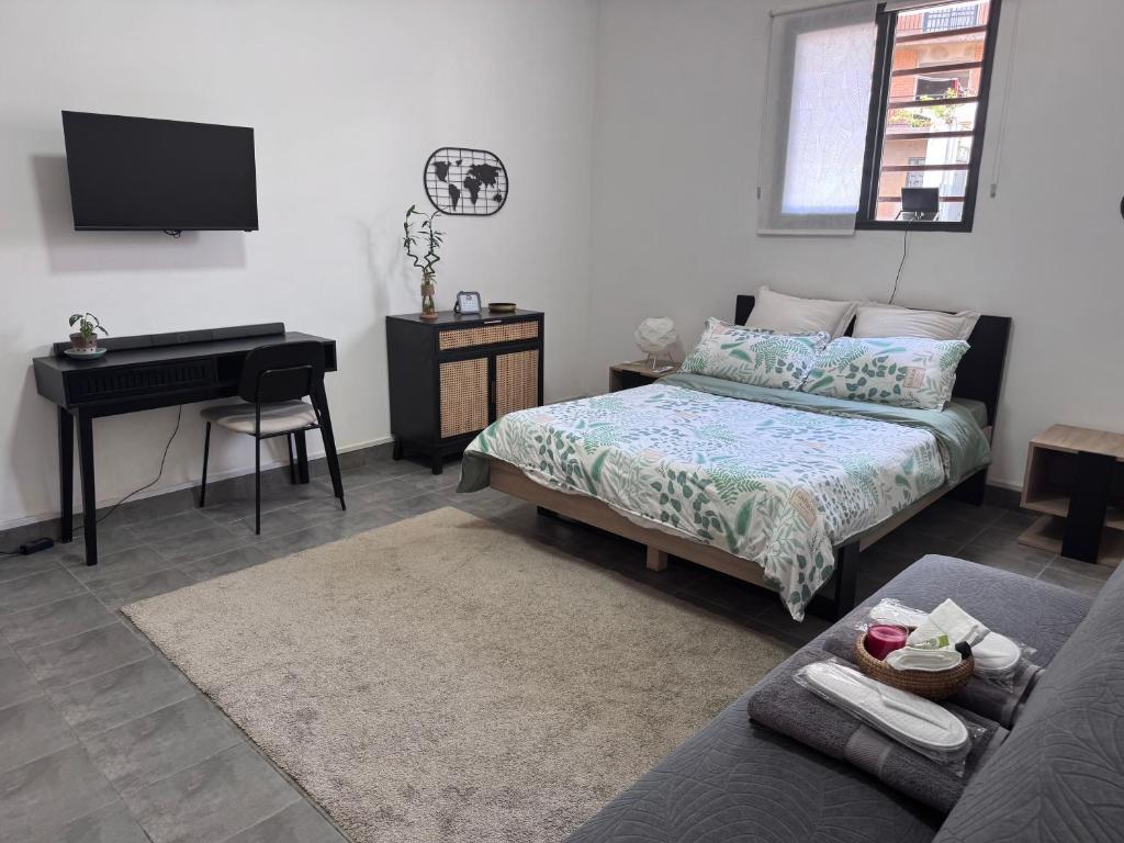Un dormitorio con una cama y una mesa y un piano. en Suites&Stay, en Antananarivo