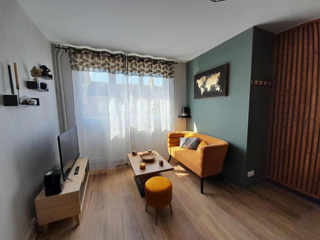 salon z kanapą i stołem w obiekcie Ravissant appart' central w mieście Châteauroux