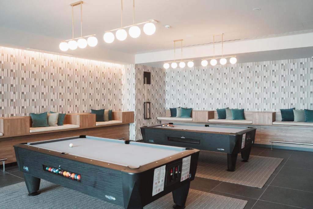 a room with two pool tables and couches at BANCAL HOTEL and SPA in San Sebastián de la Gomera